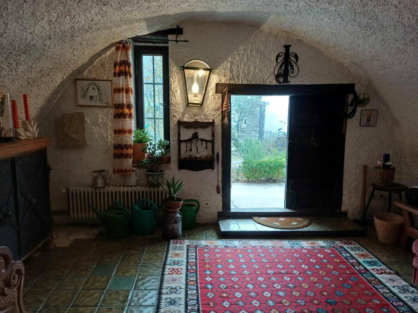 Gemütlicher Eingangsbereich mit gewölbter Decke, Fliesenboden und traditioneller Dekoration.