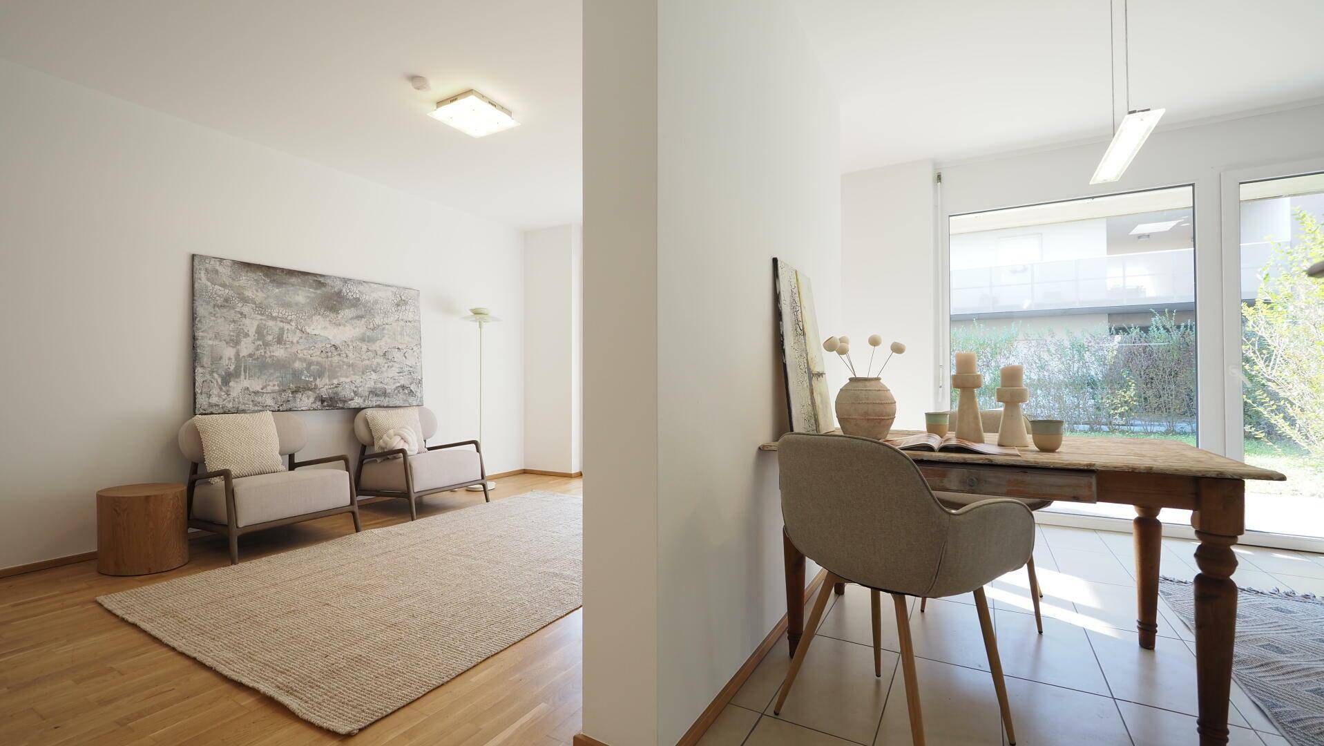 Offener Wohn- und Essbereich mit Holzboden, Teppich und Zugang zum Garten.