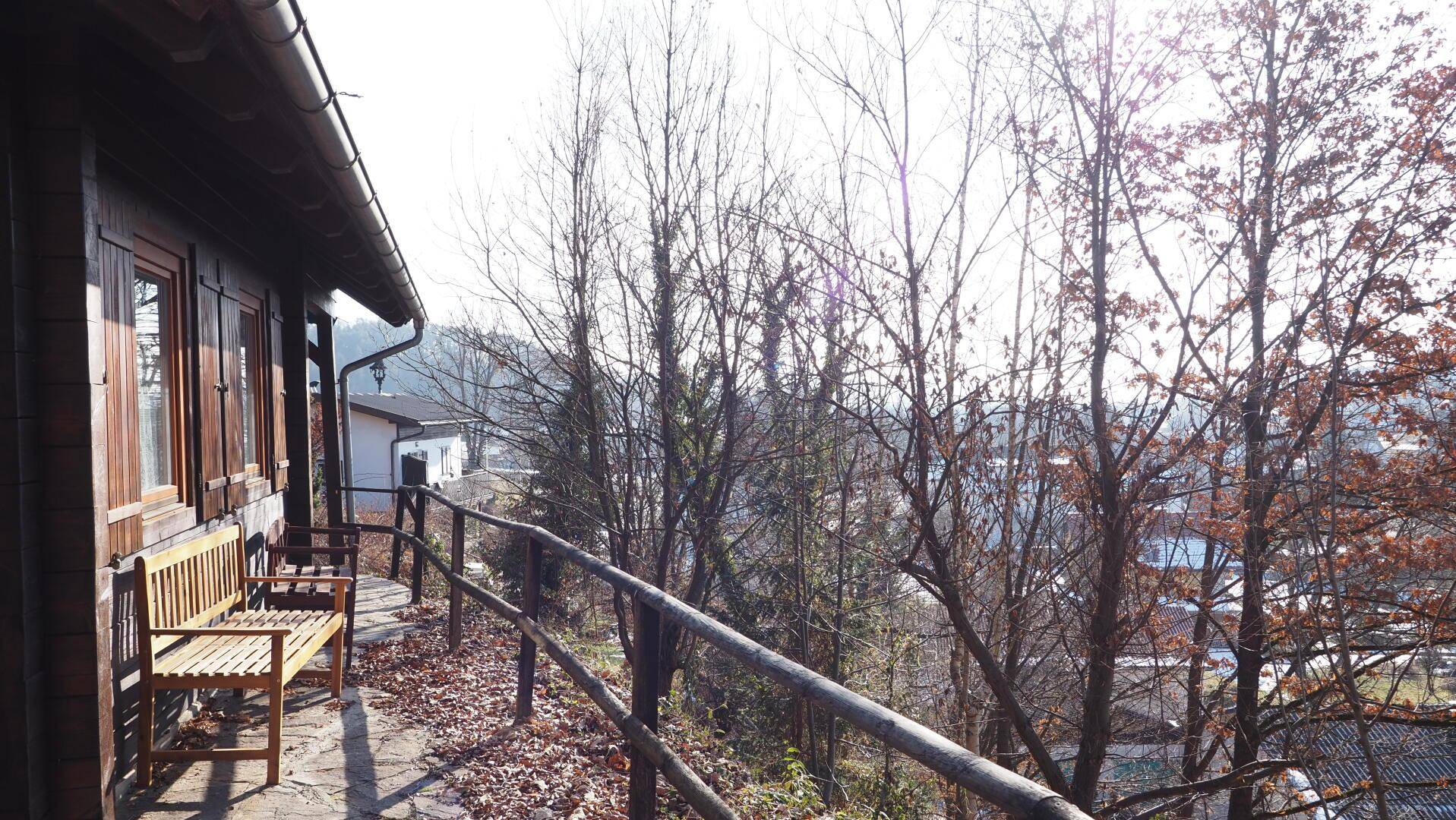 Gemütliche Terrasse mit Holzbänken und einem weiten Blick über die bewaldete Landschaft.