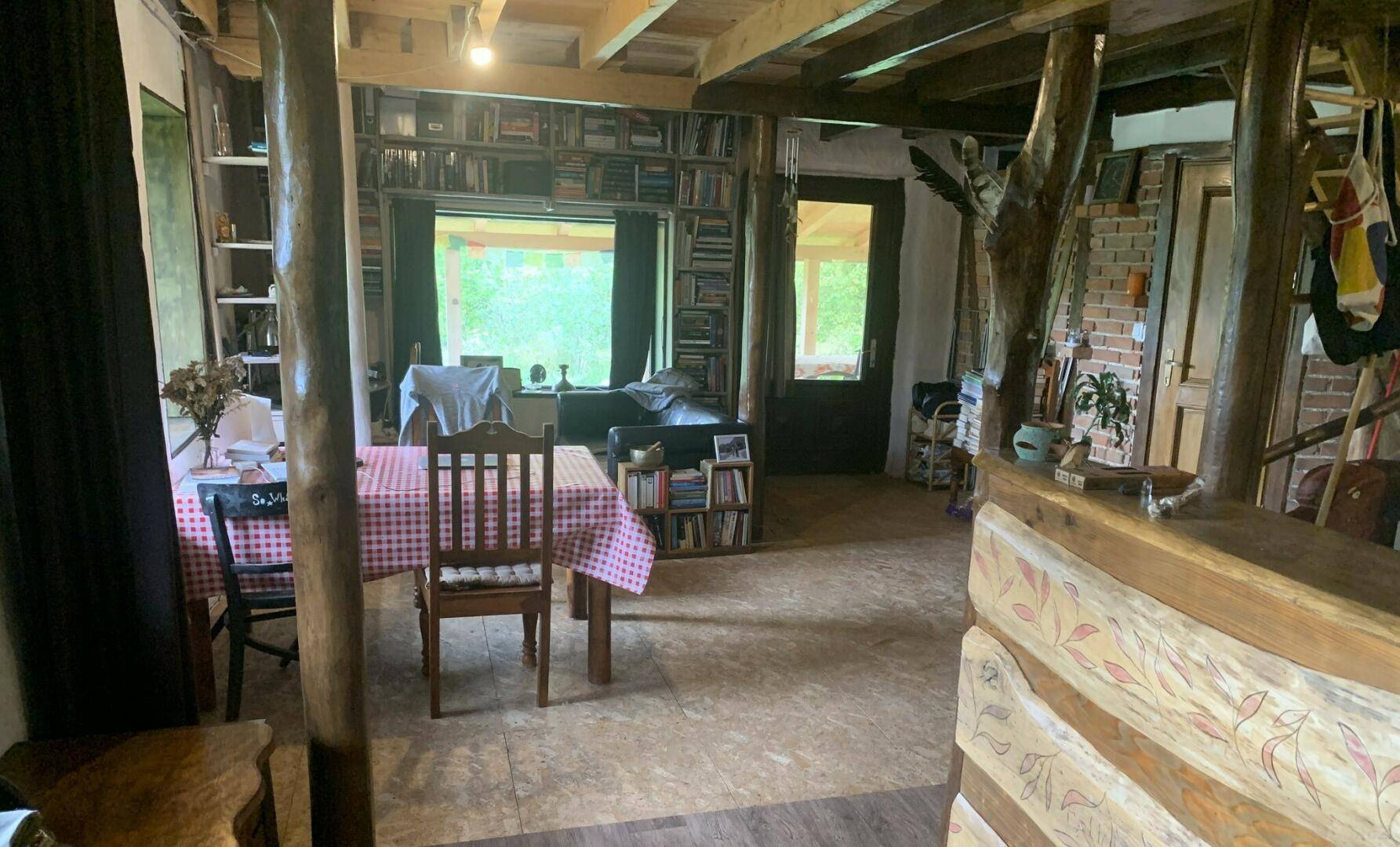 Gemütlicher Wohnbereich mit Bücherregalen, Holzelementen und Blick ins Grüne.