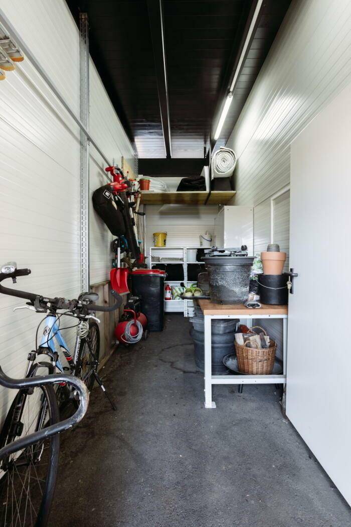 Geräumiger Abstellraum mit Fahrrädern, Werkzeugen und Regalen für Lagerung.