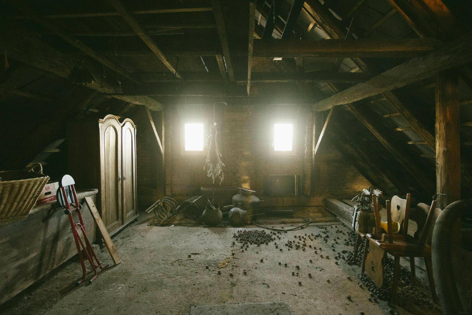 Dachboden als Lagerraum genutzt, mit Fenstern und verschiedenen Gegenständen.