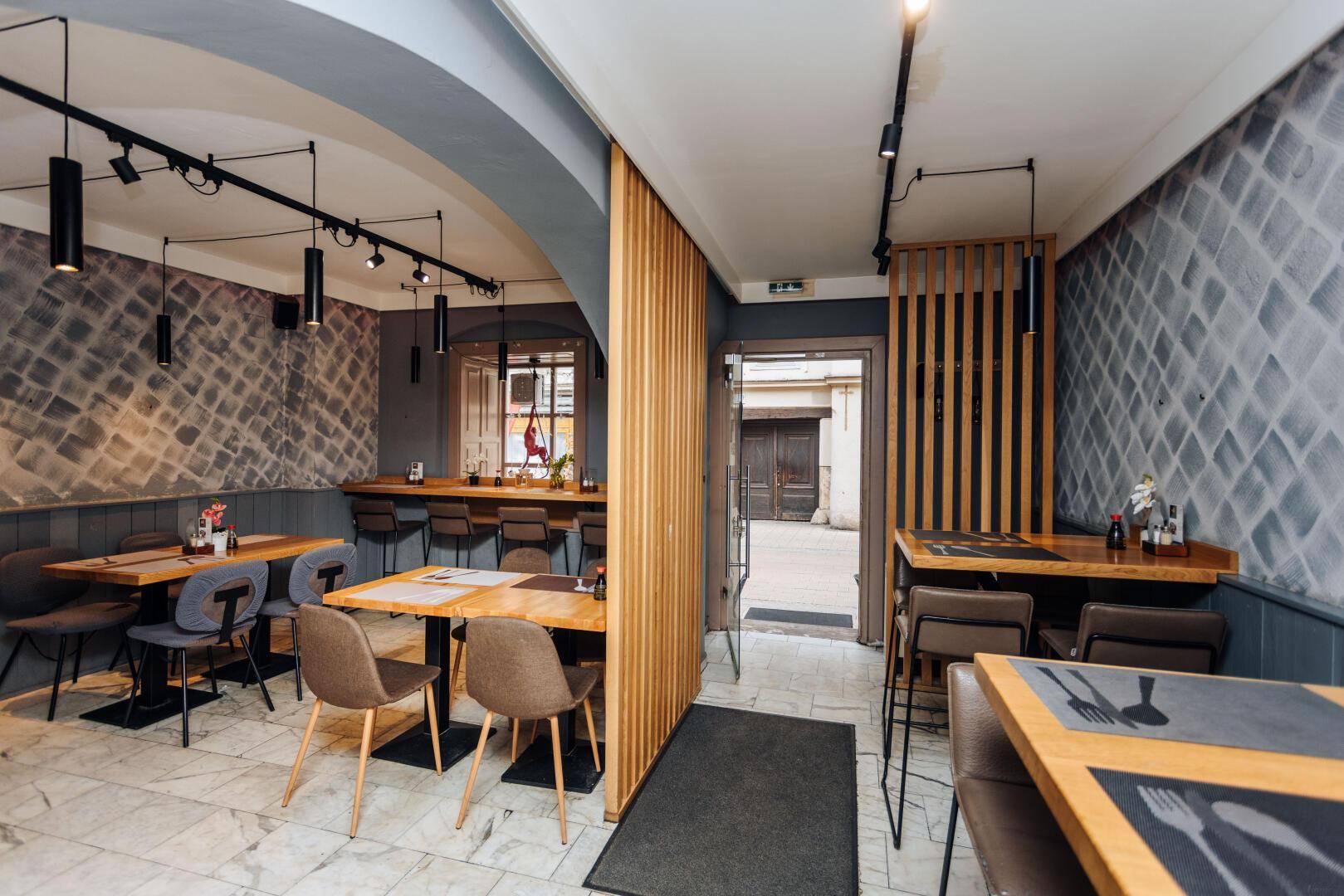 Geräumiger Restaurantbereich mit verschiedenen Sitzgelegenheiten, Holzelementen und moderner Beleuchtung für Gäste.