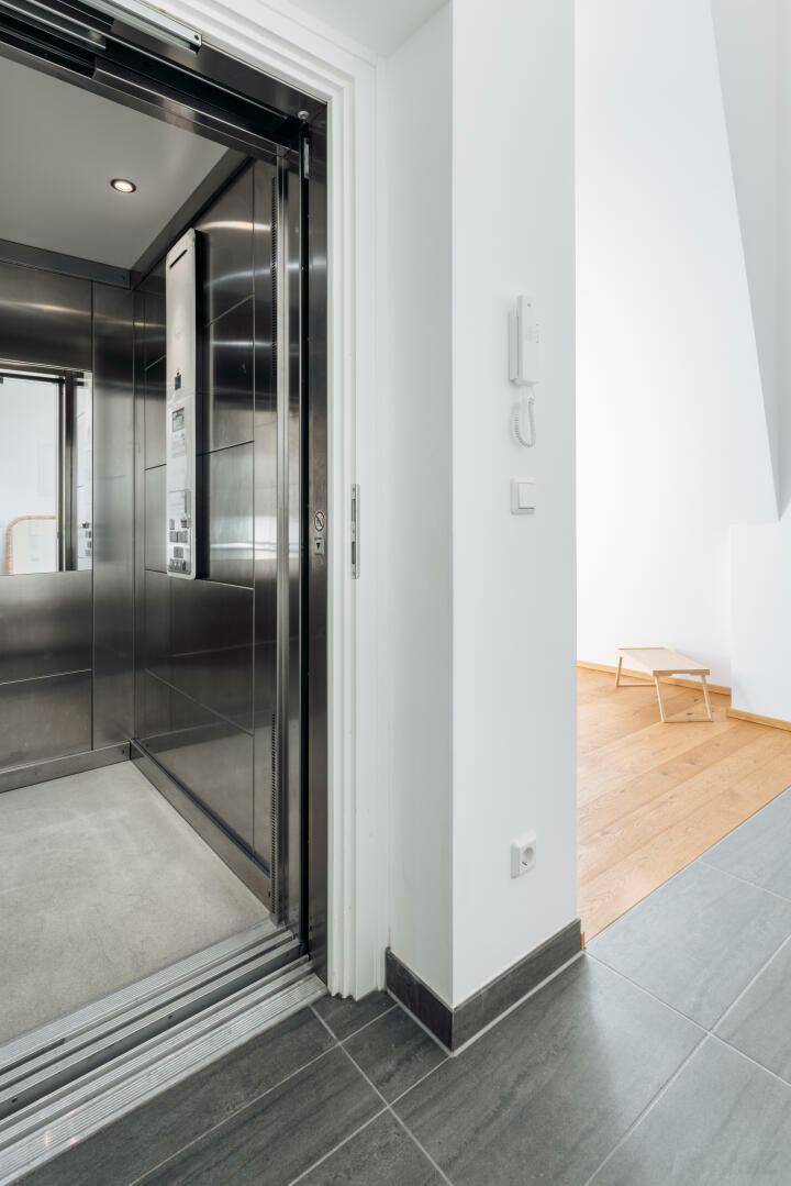Moderner Aufzug mit Edelstahloberflächen im Eingangsbereich des Penthouses für bequemen Zugang.