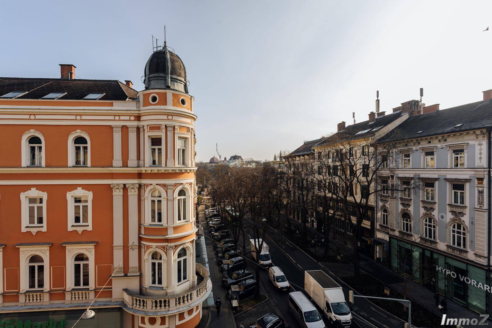 Historisches Gebäude mit Kuppel und Blick auf eine belebte Stadtstraße mit Verkehr, zeigt urbanes Flair.