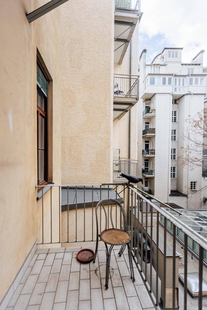 Kleiner Balkon mit Fliesenboden und Metallgeländer, bietet Blick auf den Innenhof.