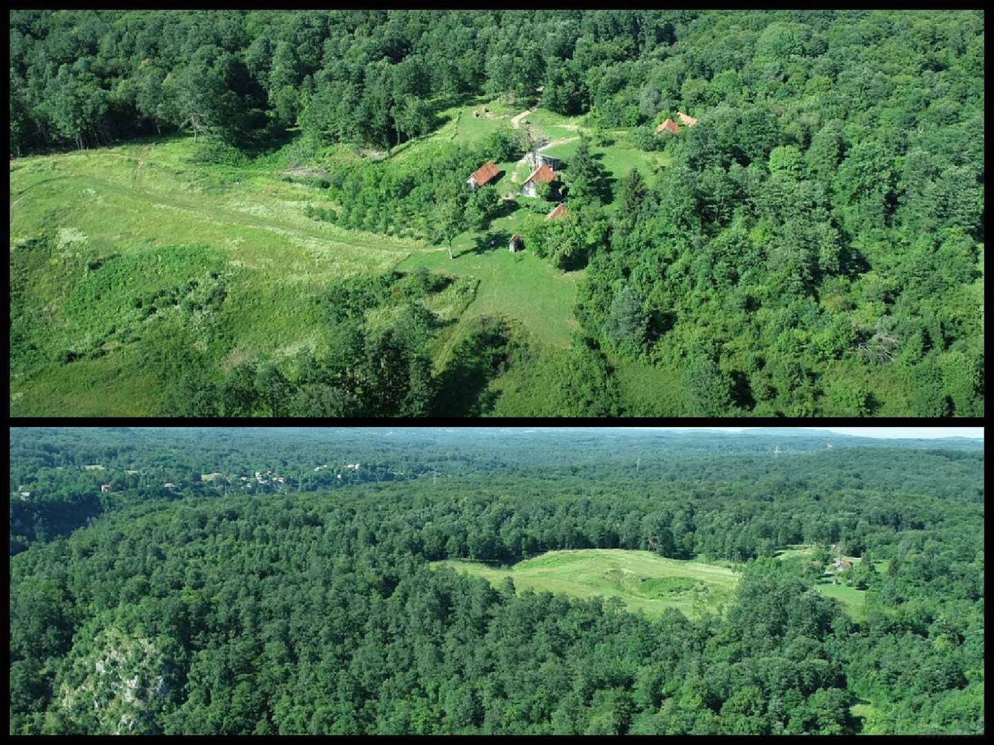 Luftaufnahme eines Anwesens umgeben von dichtem Wald und grünen Lichtungen, mit mehreren Gebäuden.