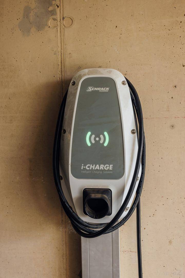 Detailaufnahme einer modernen Ladestation für Elektrofahrzeuge an einer Wand montiert.