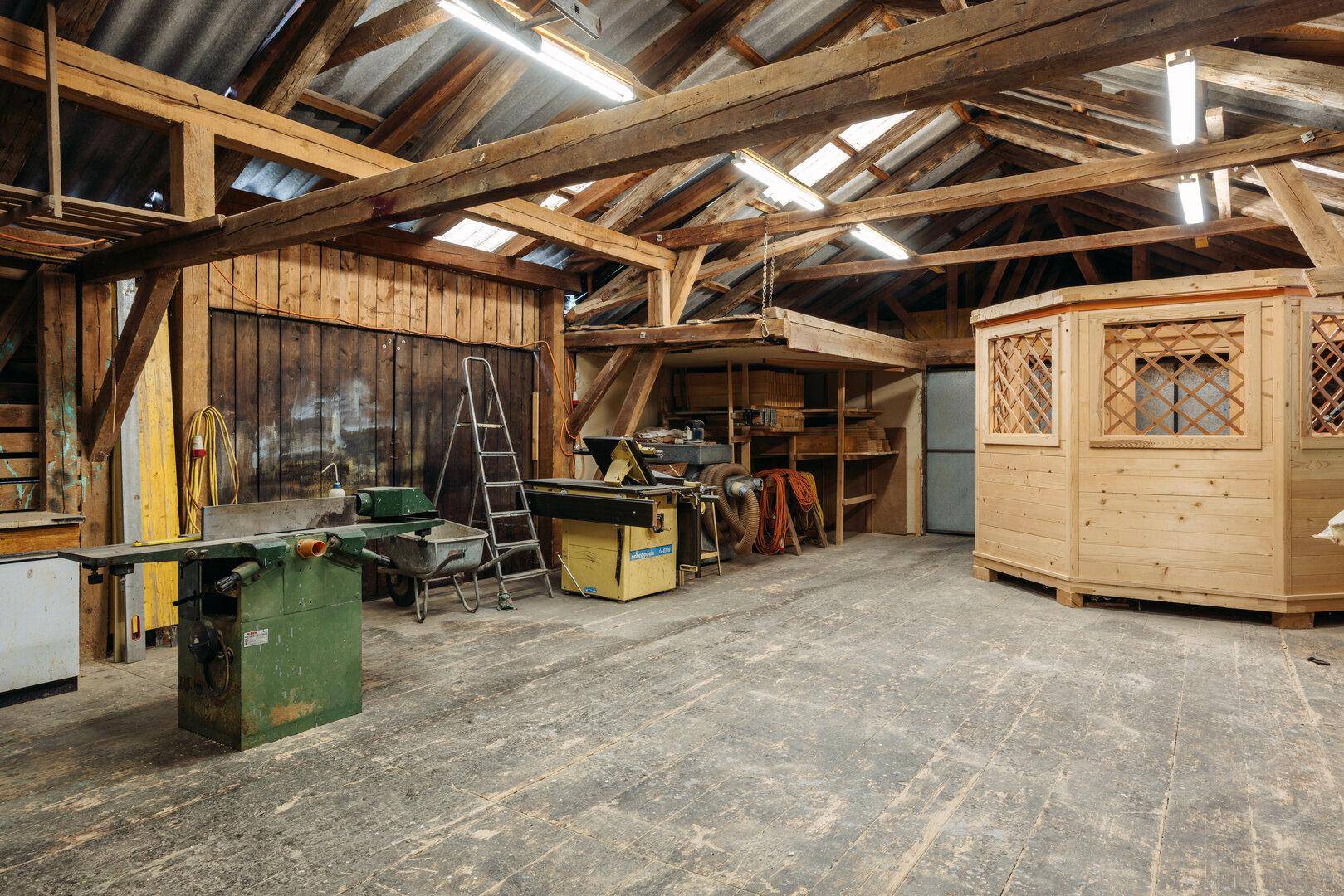 Große Werkstatt mit Holzbalken, Maschinen und viel Stauraum.
