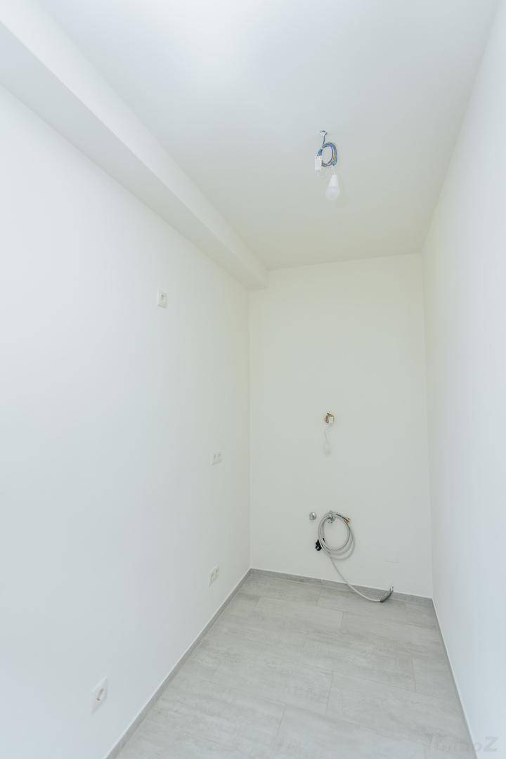 Leerer Küchenraum mit Fliesenboden und weißen Wänden, vorbereitet für die Installation einer Küche.