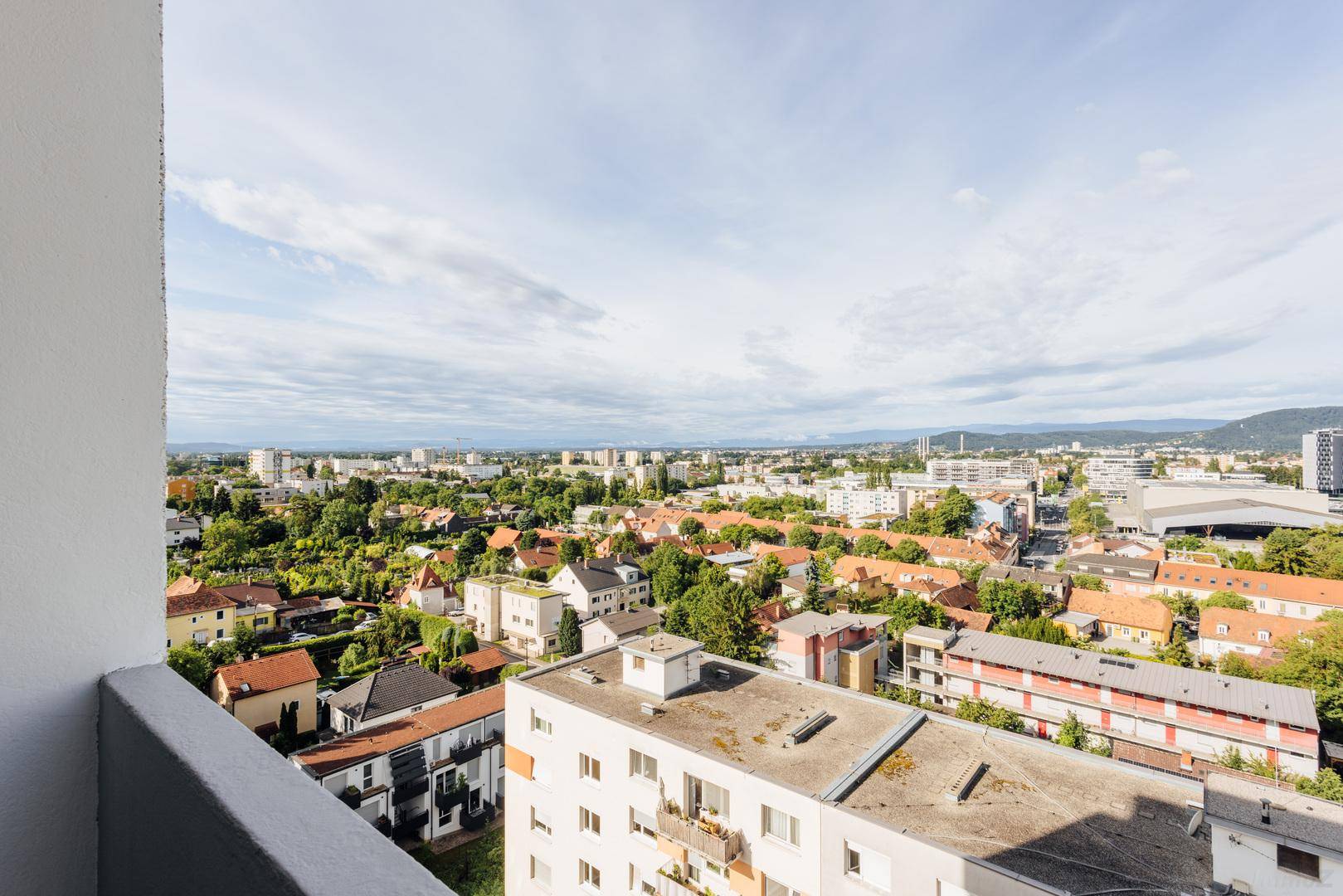 Heller Balkon mit weitem Blick über die Stadt und die umliegende Landschaft.