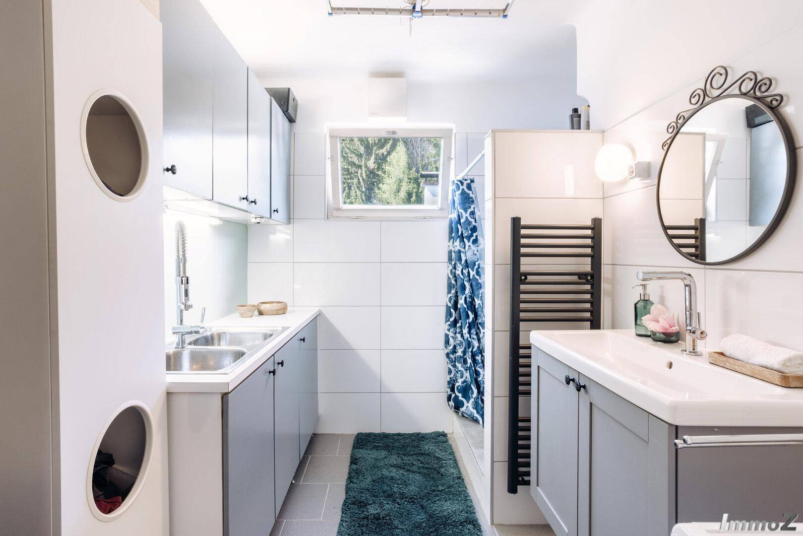 Modernes Badezimmer mit Dusche, Doppelwaschbecken und weißen Fliesen.