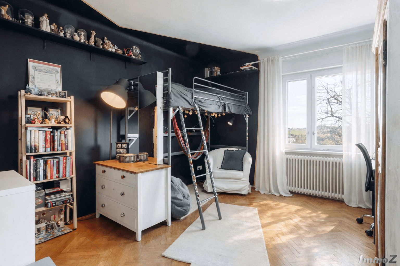 Jugendzimmer mit Hochbett, schwarzer Wand und Parkettboden.
