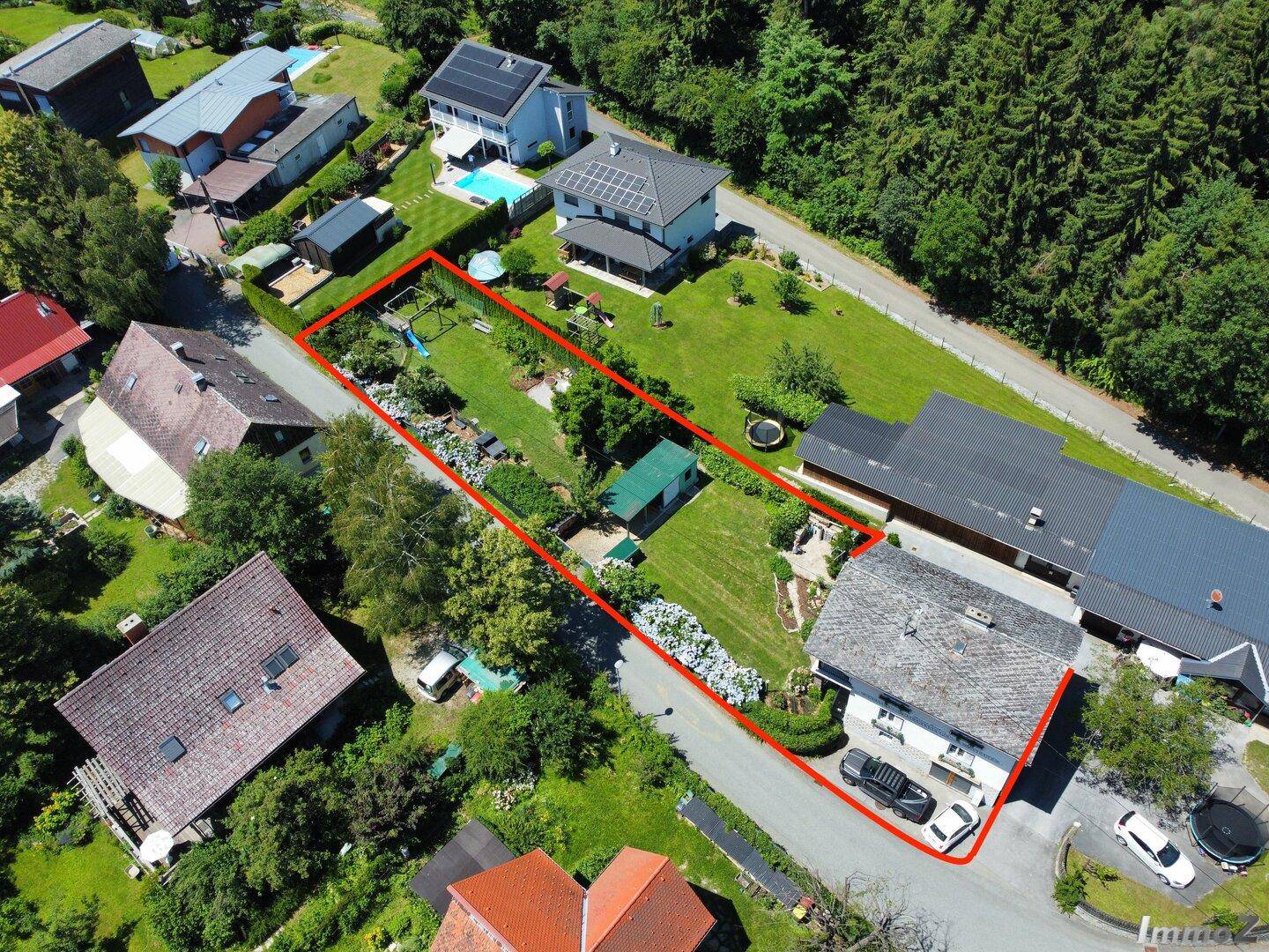 Luftaufnahme des Grundstücks mit Haus, Garten und angrenzenden Nachbargebäuden in ländlicher Umgebung.