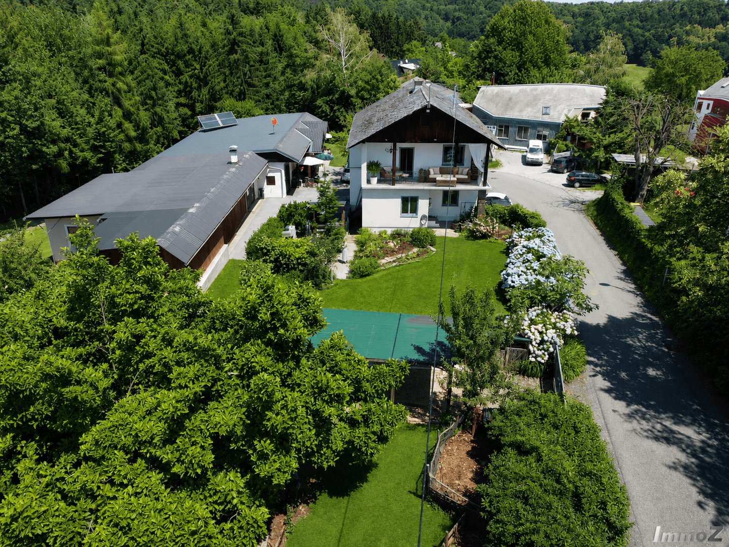 Vogelperspektive des Hauses mit großem Garten, Terrasse und umgebender grüner Landschaft.
