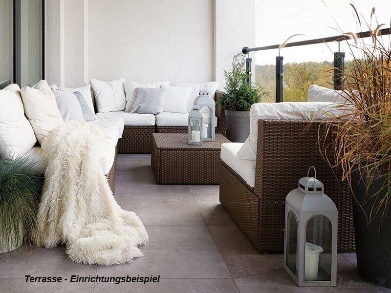 Gemütliche Terrasse mit Rattanmöbeln, weißen Kissen und dekorativen Laternen für entspannte Stunden im Freien.