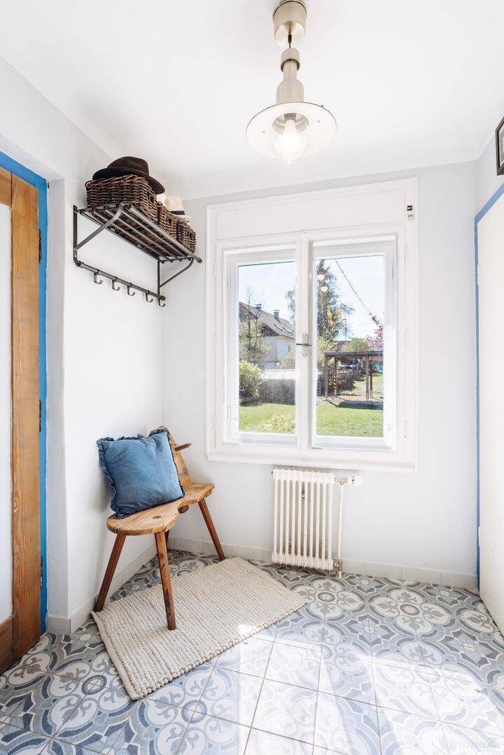 Heller Flur mit gemusterten Bodenfliesen, Fenster und Garderobenbereich.