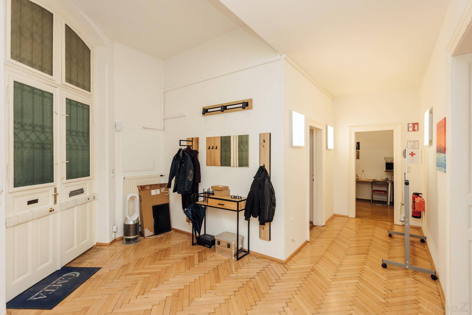 Geräumiger Eingangsbereich mit Fischgrätparkett, Garderobe und Zugang zu weiteren Räumen.