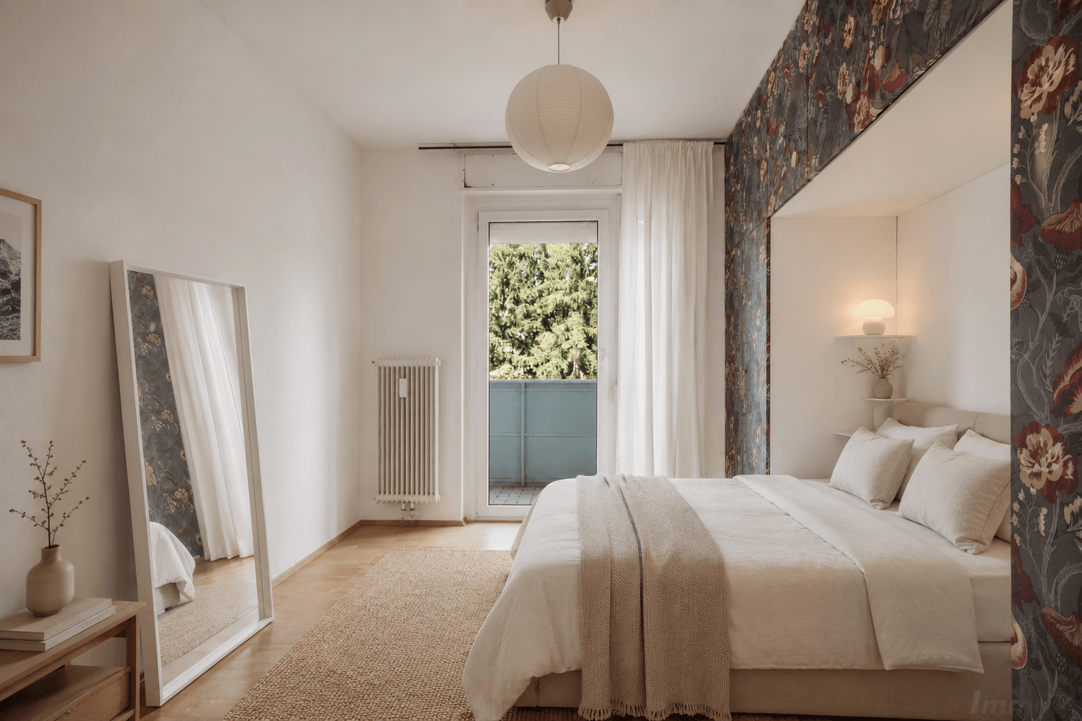 Gemütliches Schlafzimmer mit floraler Tapete, Holzboden und Balkonzugang.