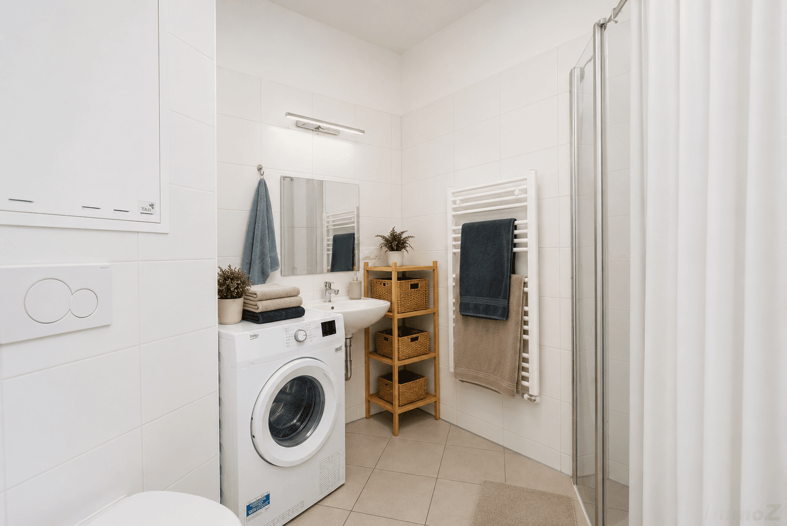 Modernes Badezimmer mit Dusche, Waschmaschine und beheiztem Handtuchhalter.