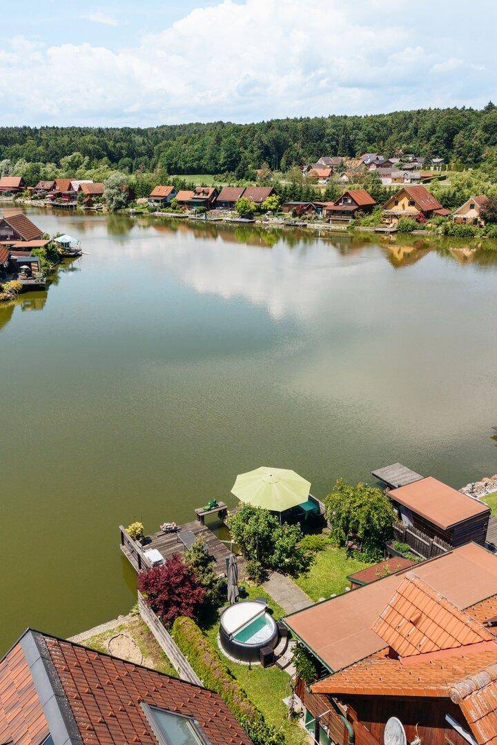Luftaufnahme des Anwesens mit Seezugang, Whirlpool und umliegender Naturlandschaft.