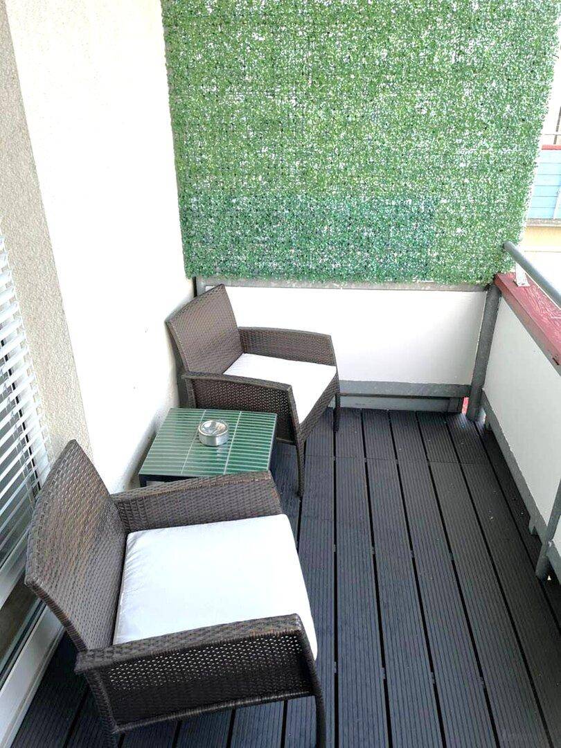 Kleiner Balkon mit Sitzgelegenheiten und Sichtschutz, ideal für entspannte Stunden.