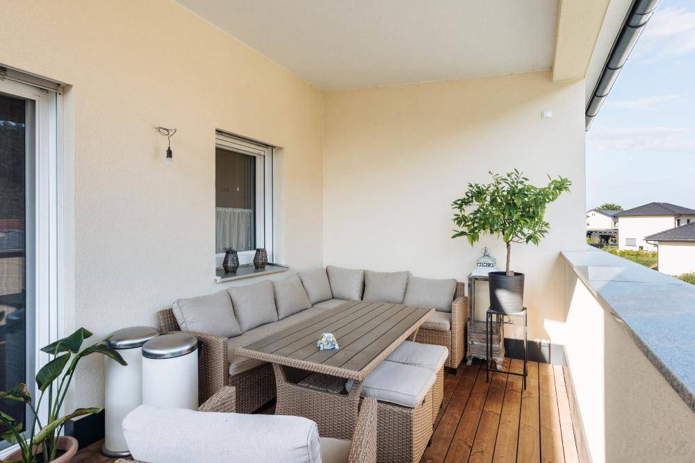 Geräumiger Balkon mit bequemen Outdoor-Möbeln und Blick auf die Umgebung.