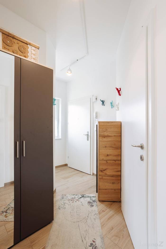 Heller Flur mit Holzfußboden, Spiegelschrank und praktischem Schuhschrank.