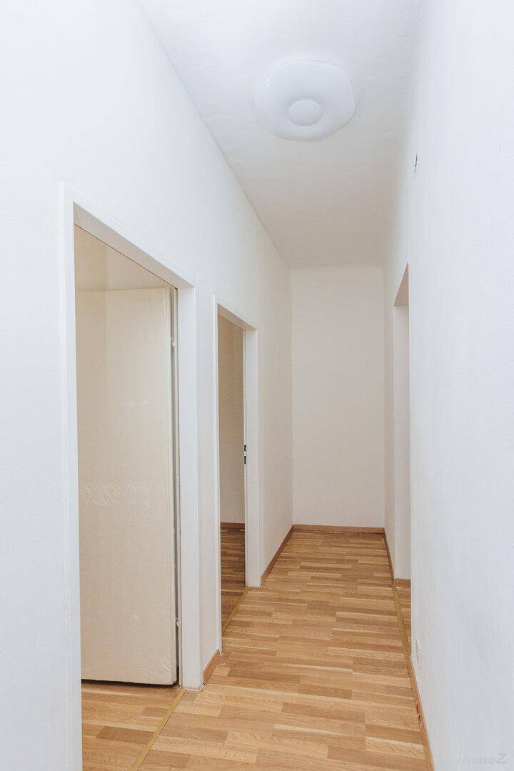 Heller Flur mit Parkettboden und mehreren Türen, der verschiedene Räume miteinander verbindet.