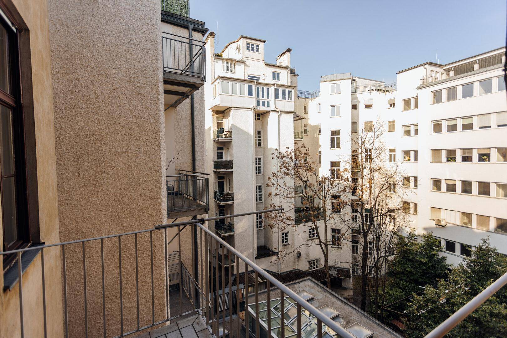 Balkon mit Blick auf den ruhigen Innenhof und die umliegenden historischen Gebäude der Stadt.