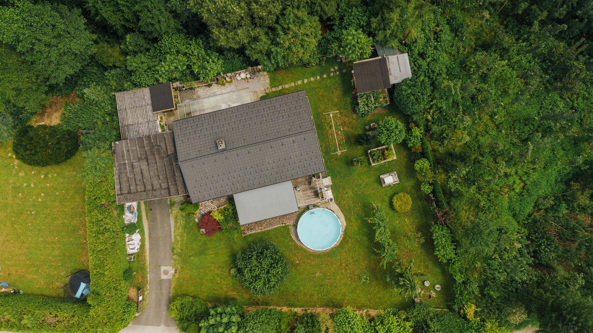 Übersicht des Anwesens aus der Vogelperspektive mit Haus, Garten und Pool.