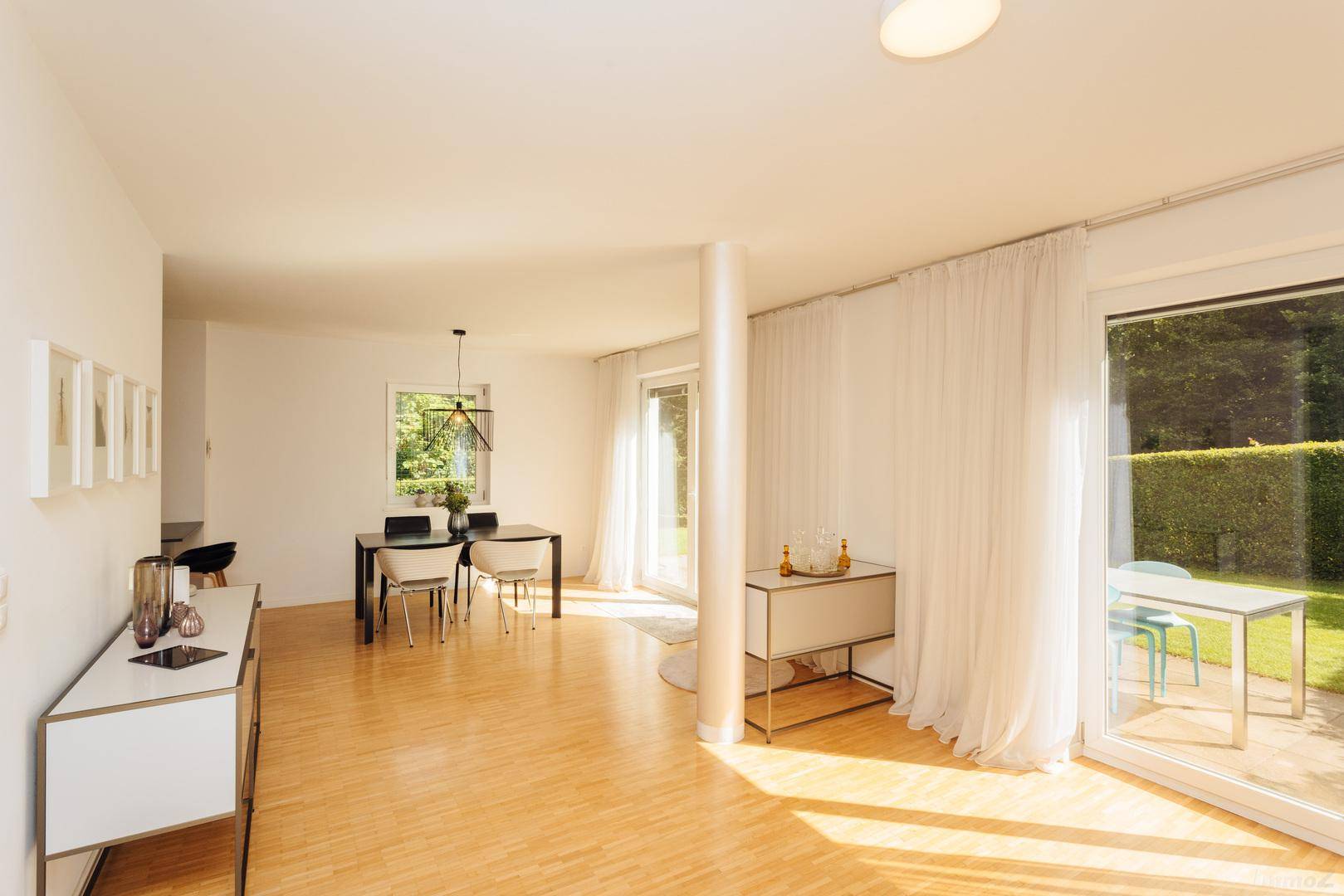 Lichtdurchfluteter Wohn-Essbereich mit Holzboden, großen Fenstern und Terrassenzugang.