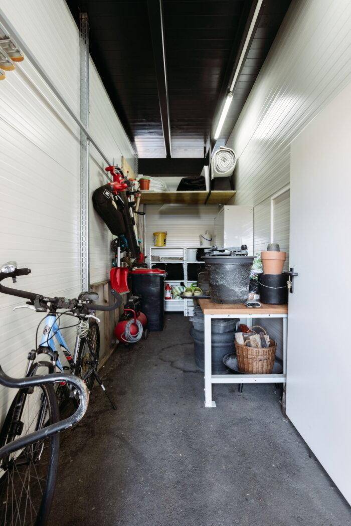 Praktischer Abstellraum mit Fahrradstellplatz, Werkbank und Regalen für diverse Utensilien.