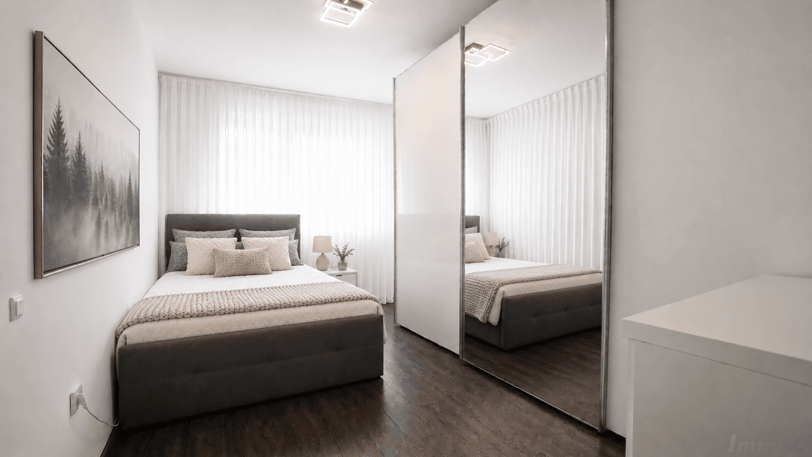 Helles Schlafzimmer mit Doppelbett, dunklem Holzboden und Spiegelschränken.