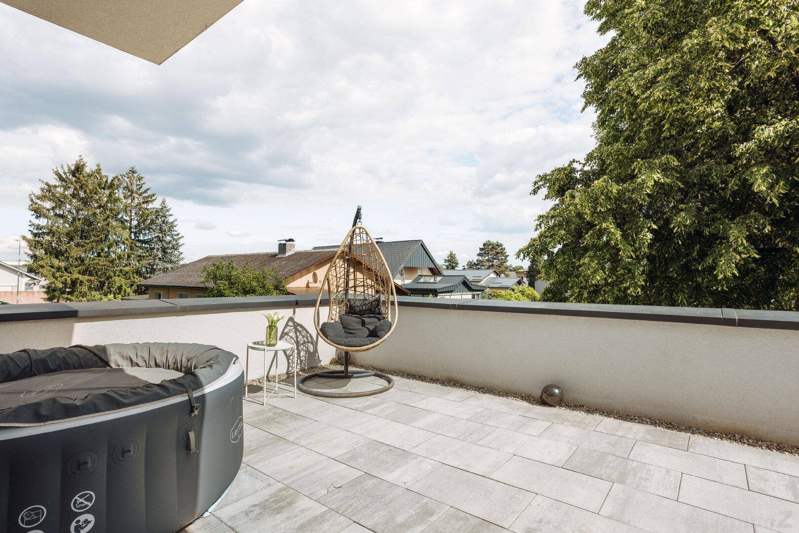Entspannungsterrasse mit Whirlpool, Hängesessel und weitem Blick in die Natur.