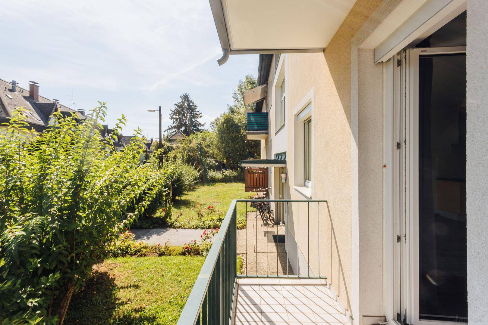Balkon mit Blick auf den gepflegten Garten und die umliegende Wohngegend.