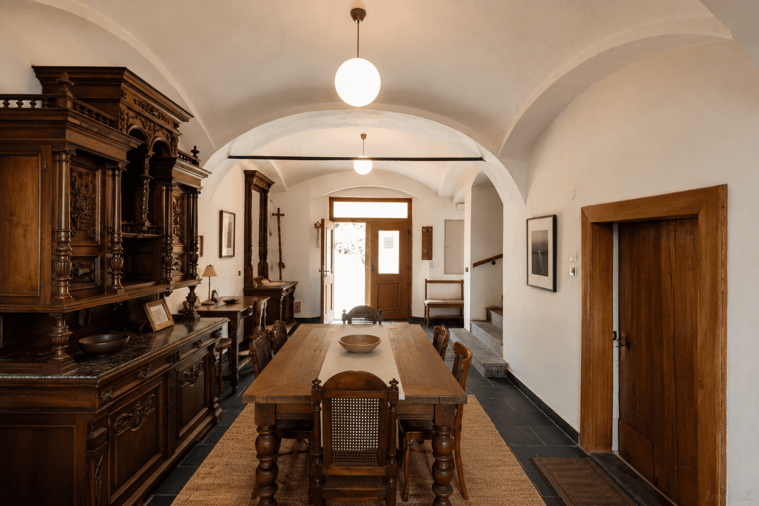 Historischer Essbereich mit gewölbter Decke, großem Holztisch und antiken Möbeln.