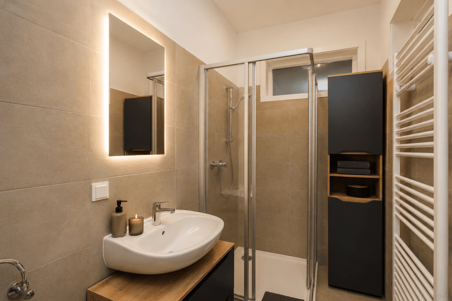 Modernes Badezimmer mit begehbarer Dusche, Einzelwaschbecken und beheiztem Handtuchhalter.
