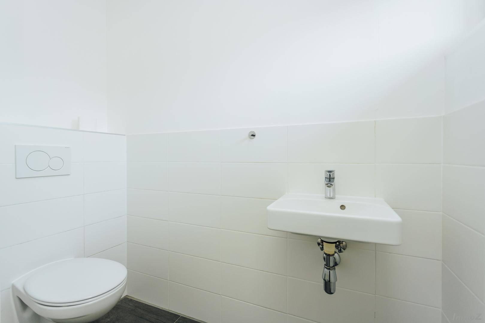 Kleines, modernes Gäste-WC mit Wand-WC und Handwaschbecken.