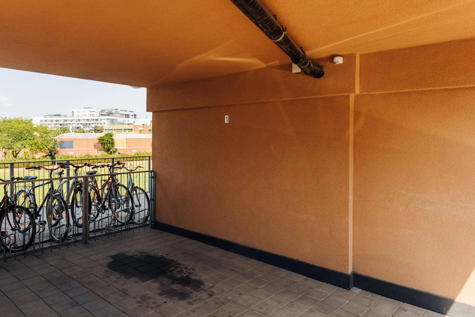 Überdachter Bereich mit Fahrradabstellplätzen unter dem Gebäude.