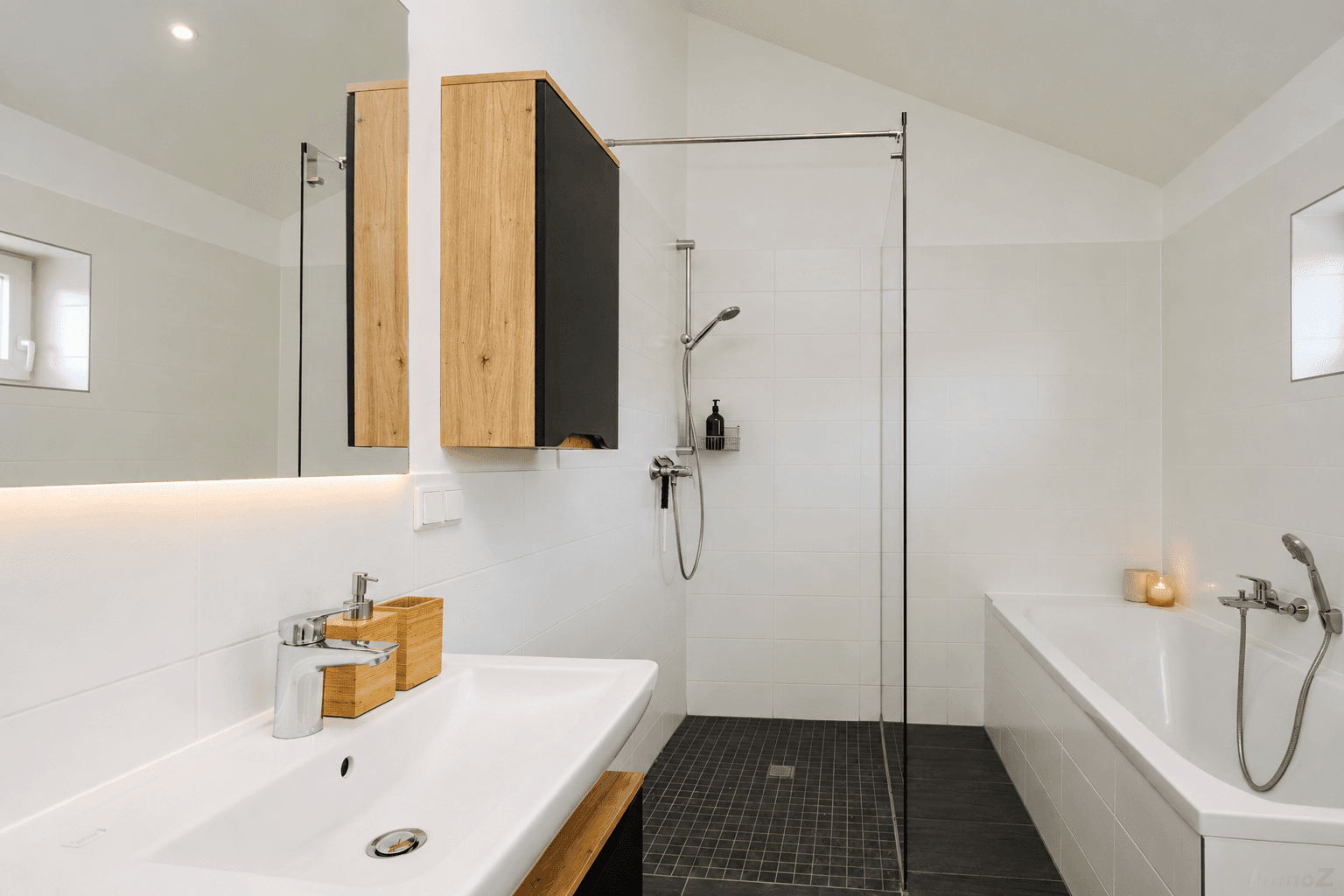 Stilvolles Badezimmer mit Badewanne, Dusche und beleuchtetem Spiegel, modern eingerichtet.