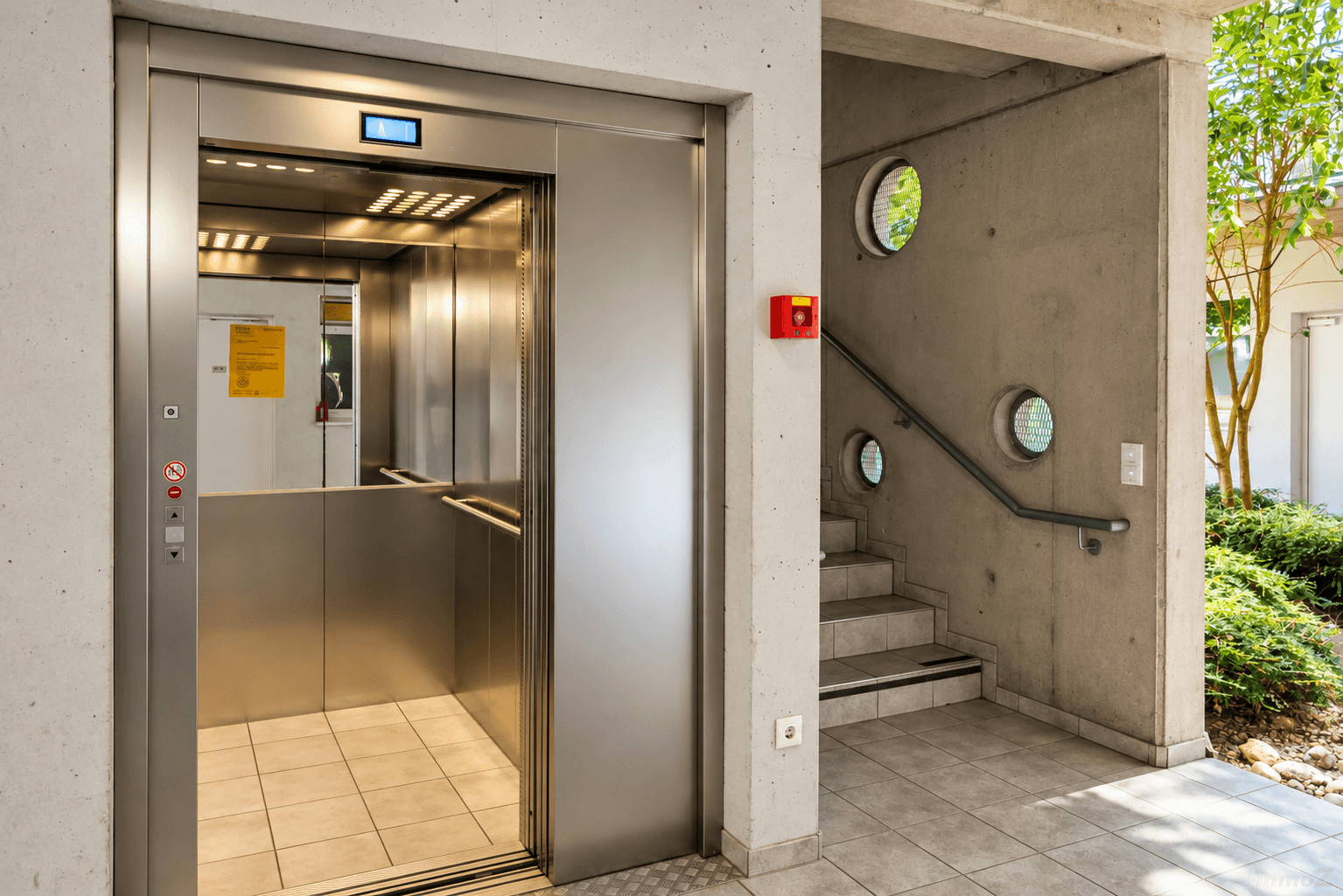 Moderner Eingangsbereich mit Aufzug und Treppe