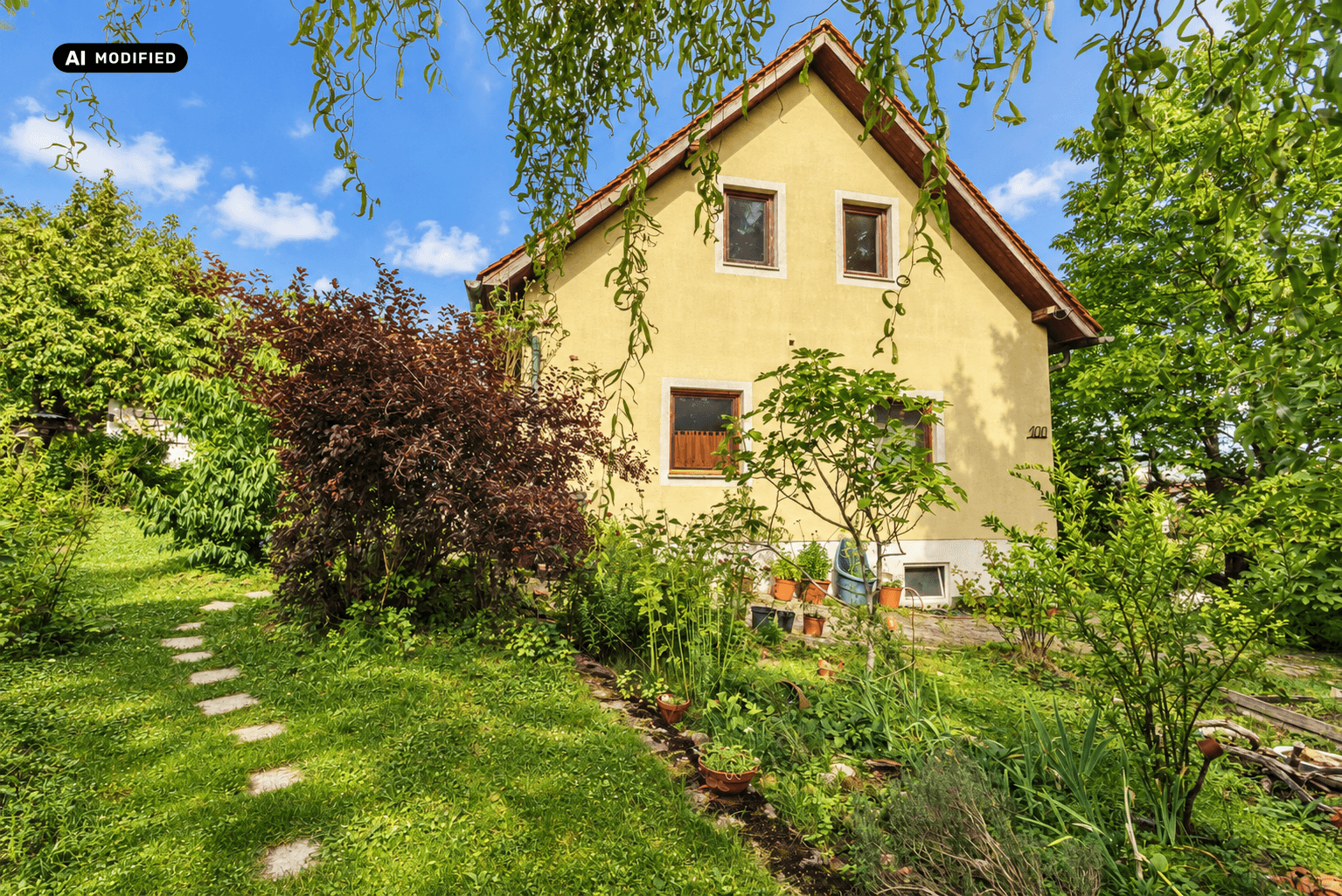 Vorderansicht des Hauses mit gelber Fassade und einem gepflegten Vorgarten mit Steinpfad.