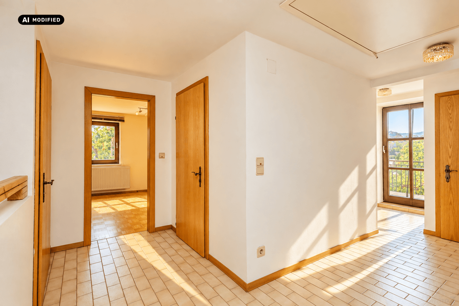 Helle Diele mit Fliesenboden, Holztüren und Zugang zu einem Balkon mit Weitblick.