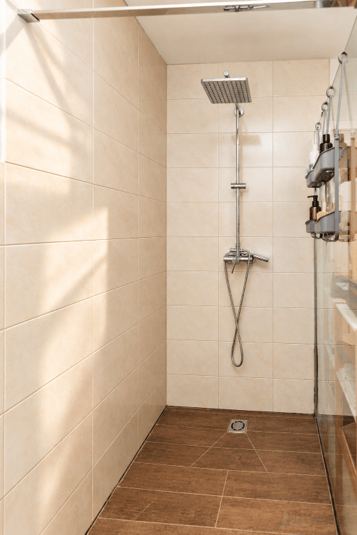 Geräumige Duschkabine mit Regendusche und beigefarbenen Fliesen.