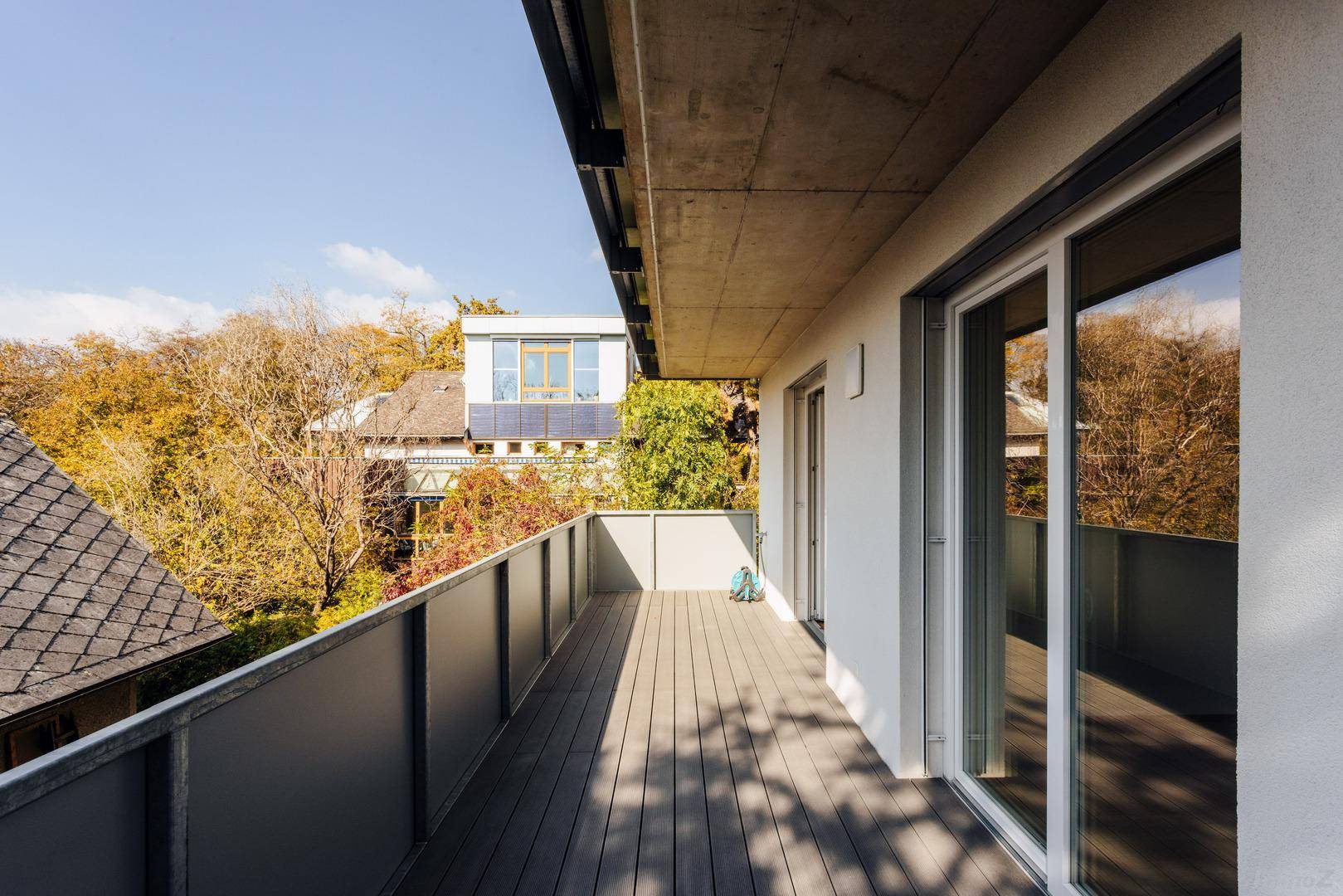 Geräumiger Balkon mit Holzdielen und Blick auf die umliegende grüne Landschaft.
