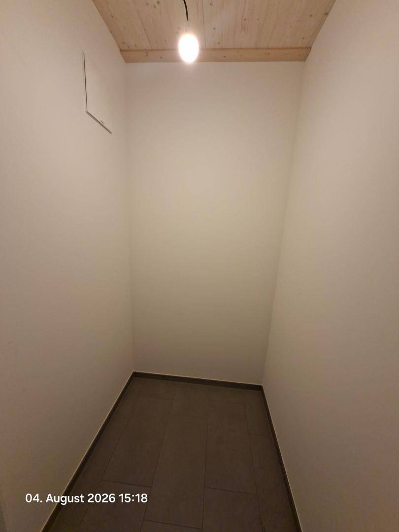 Leerer Abstellraum mit Fliesenboden und einfacher Beleuchtung.