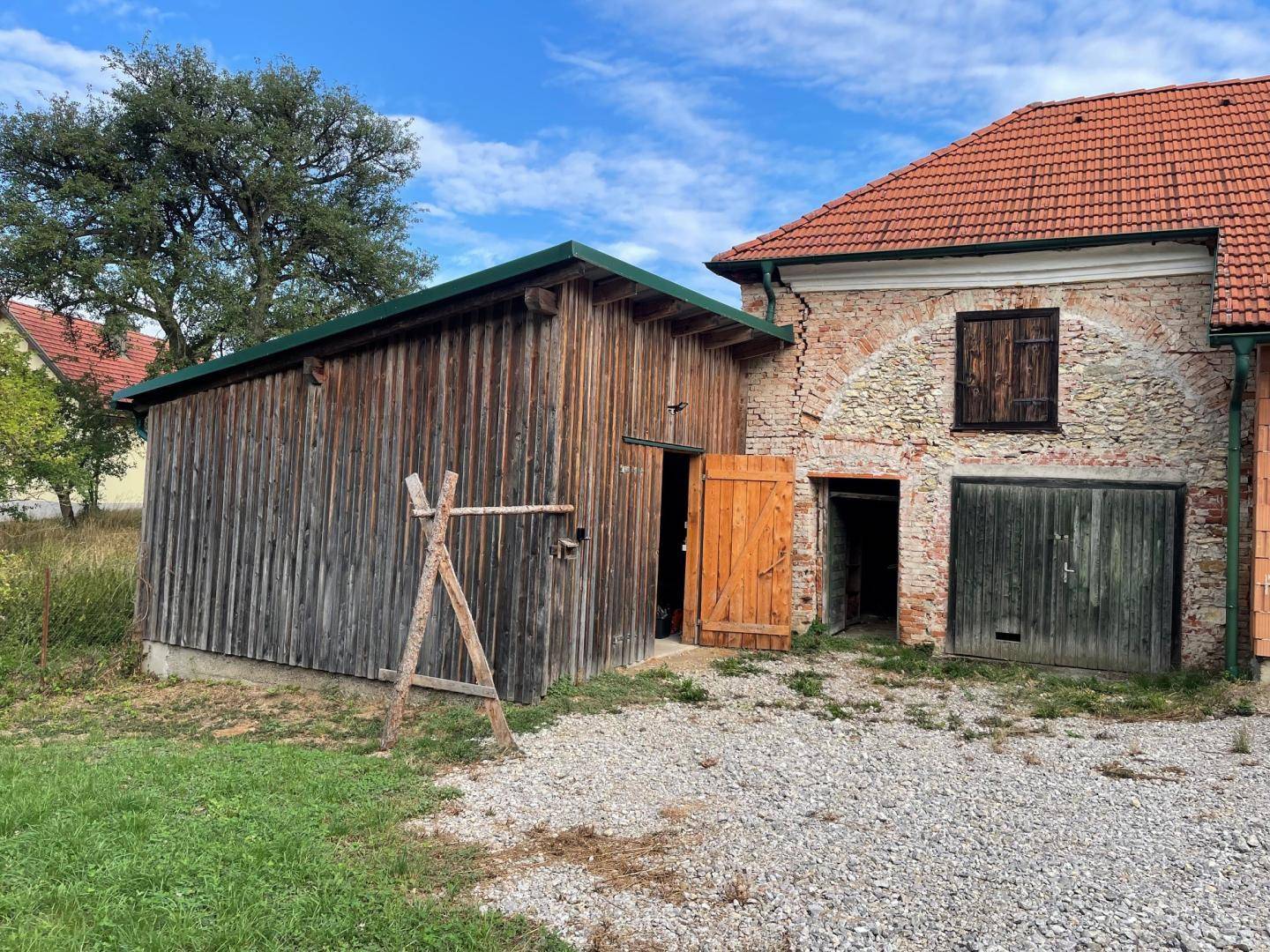 Detailansicht des Holzschuppens und eines Teils des alten Gebäudes mit Holztür.