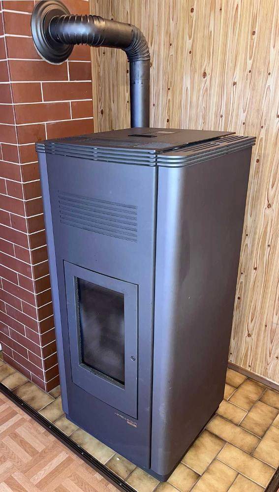 Moderner Holzofen mit Anschluss an den Schornstein, sorgt für wohlige Wärme.