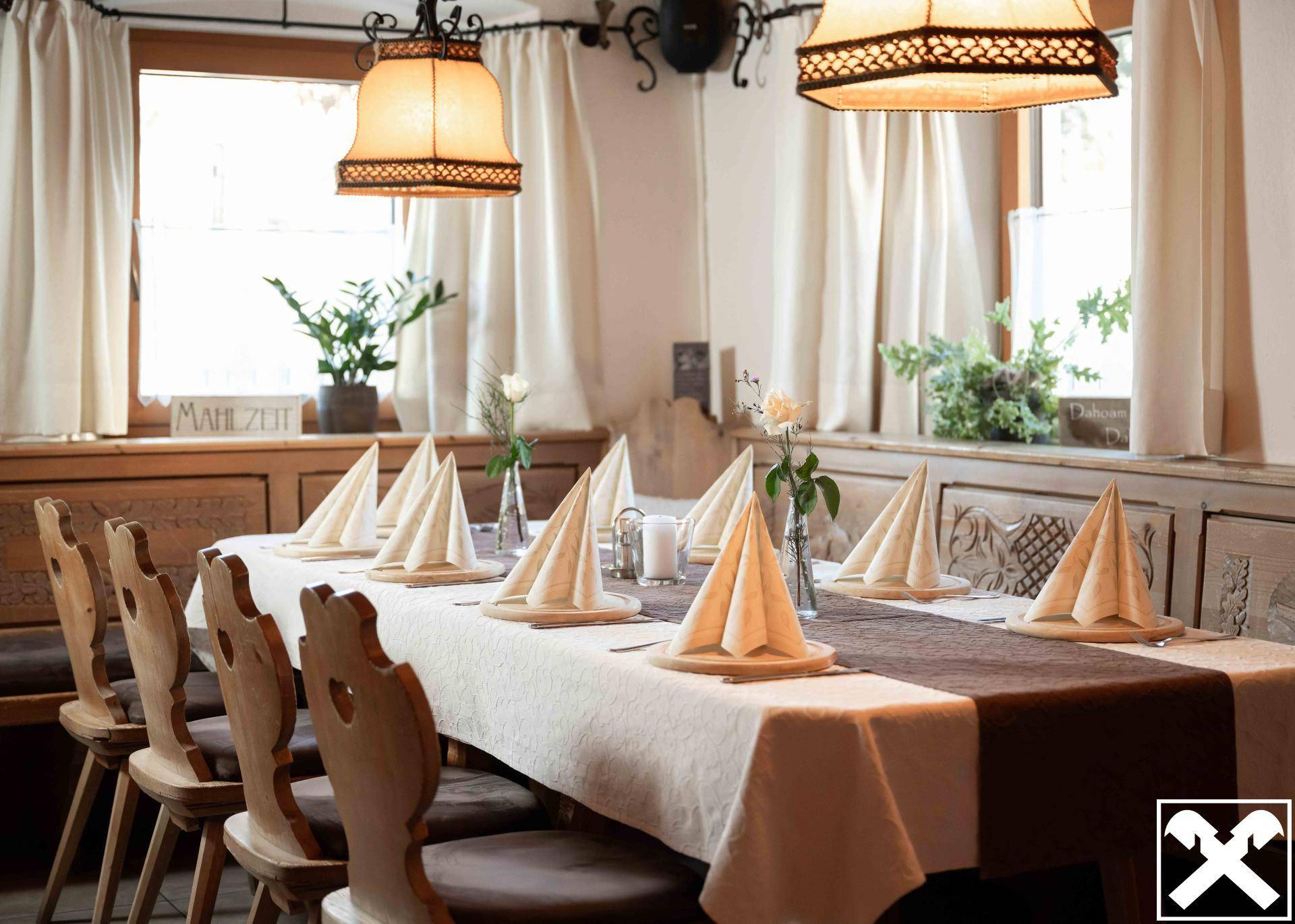 Traditioneller Essbereich mit Holzbänken, gedecktem Tisch und warmem Licht, ideal für gemütliche Mahlzeiten.